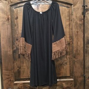 Black dress with tan fringe sleeves.